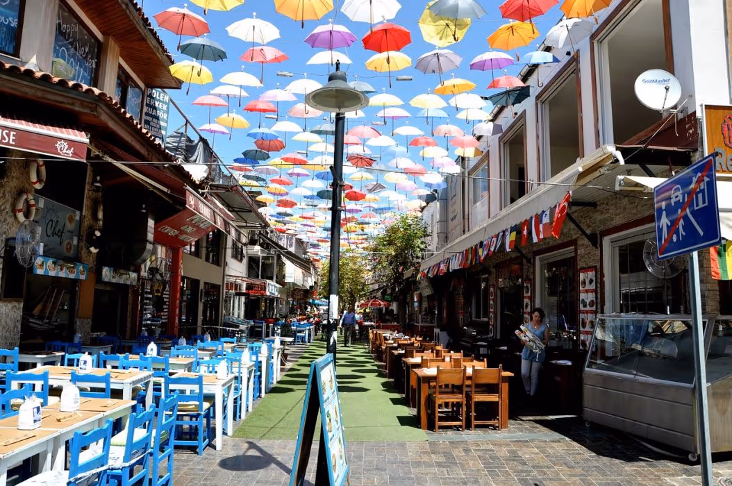 Straat met terrassen onder hangende gekleurde paraplu's in Antalya