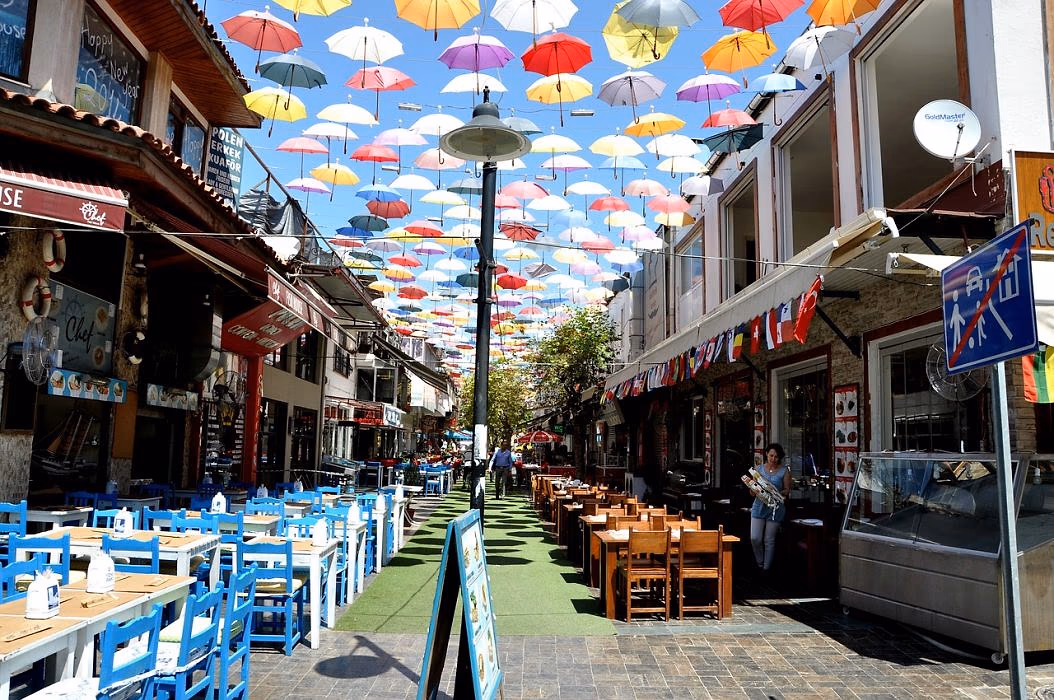 Straat met terrassen onder hangende gekleurde paraplu's in Antalya