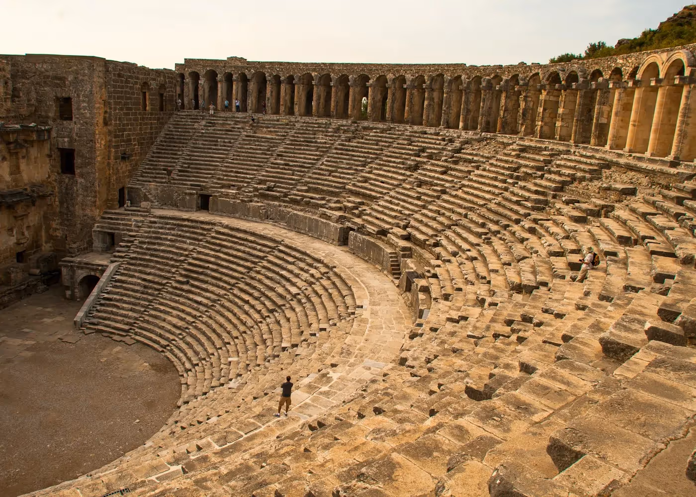 Halfronde rijen stenen zitplaatsen in het Romeinse theater van Aspendos