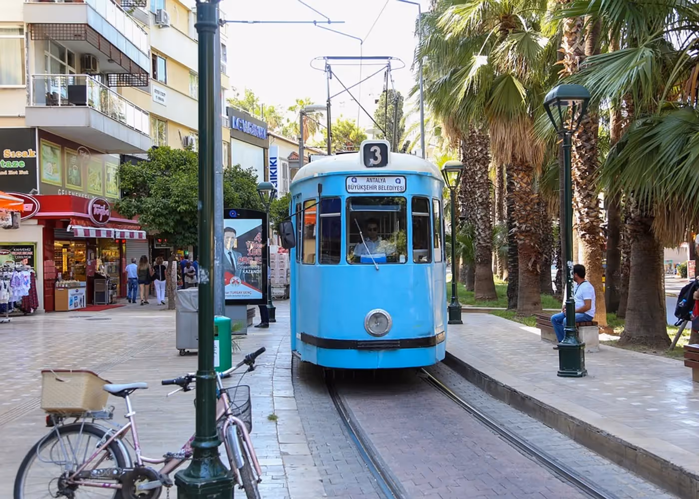 Ouderwetse tram tussen palmbomen in een straat in het centrum van Antalya