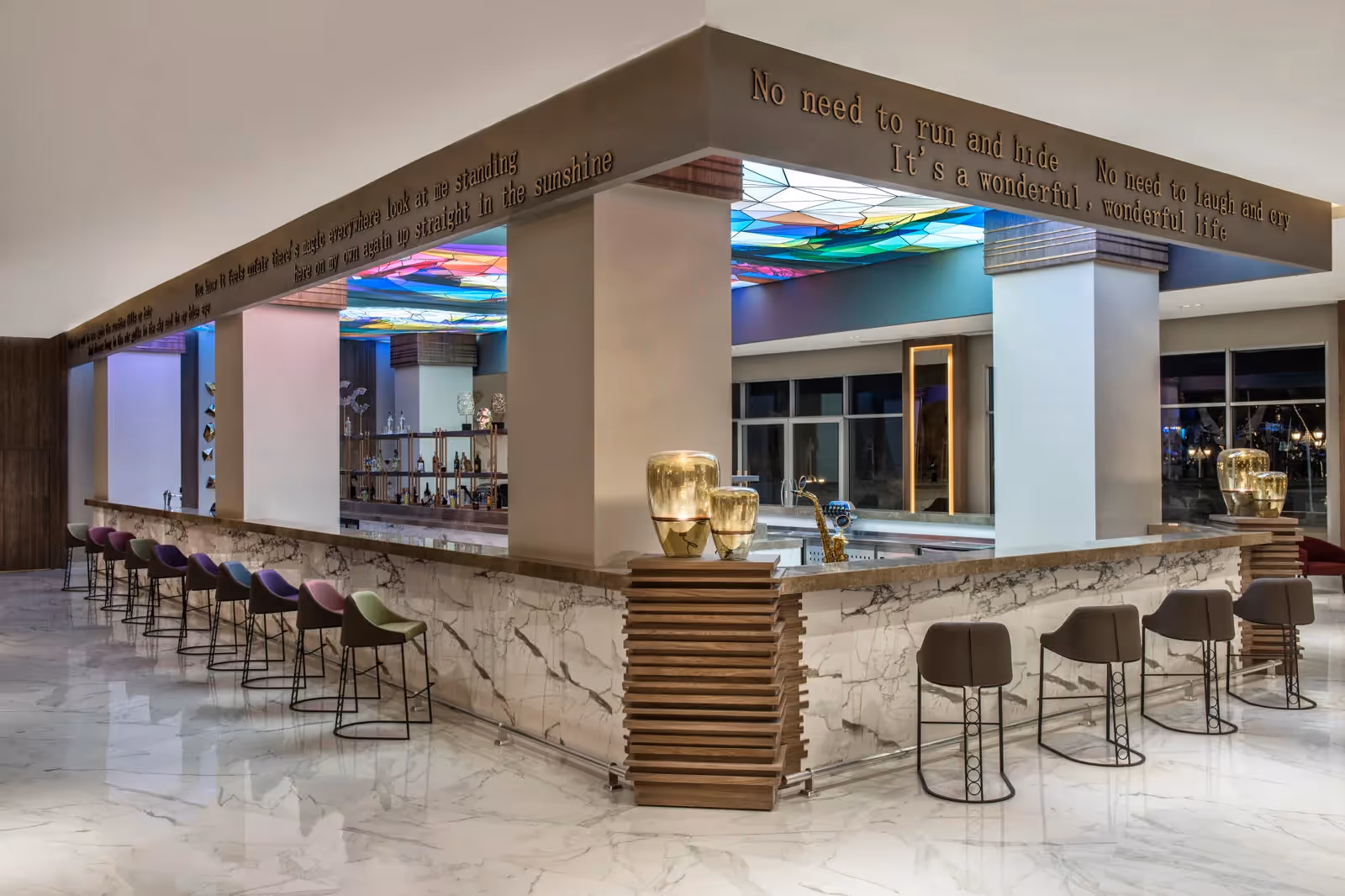 Bar met een marmeren toog en hoge barkrukken in Delphin BE Grand Resort in Lara