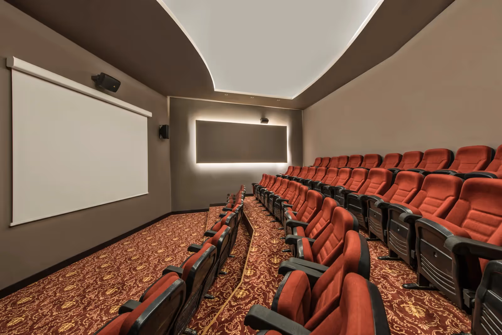 Bioscoopzaal met rode stoelen en een groot scherm in Delphin BE Grand Resort in Lara