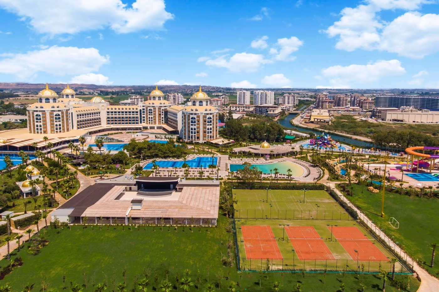 Luchtfoto van Delphin BE Grand Resort in Lara met de gebouwen, de zwembaden, het waterpark en de tennisbanen