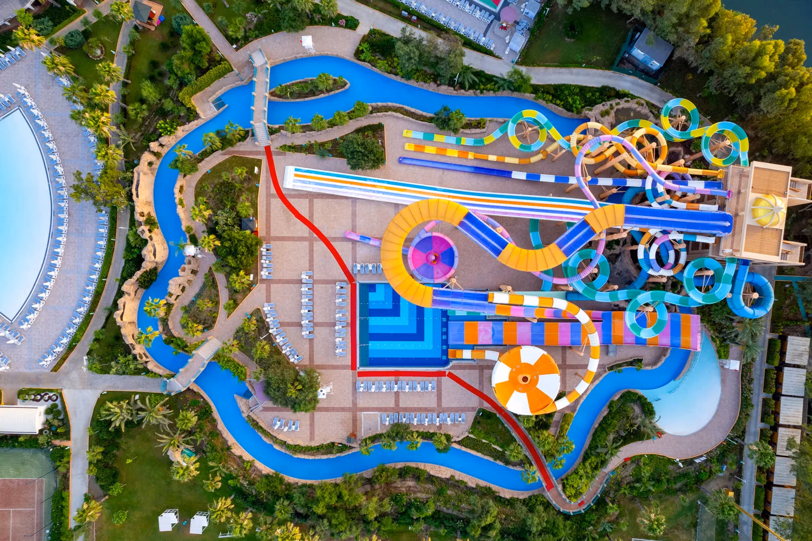 Luchtfoto recht van boven op het waterpark met gekleurde glijbanen en de lazy river van Delphin BE Grand Resort